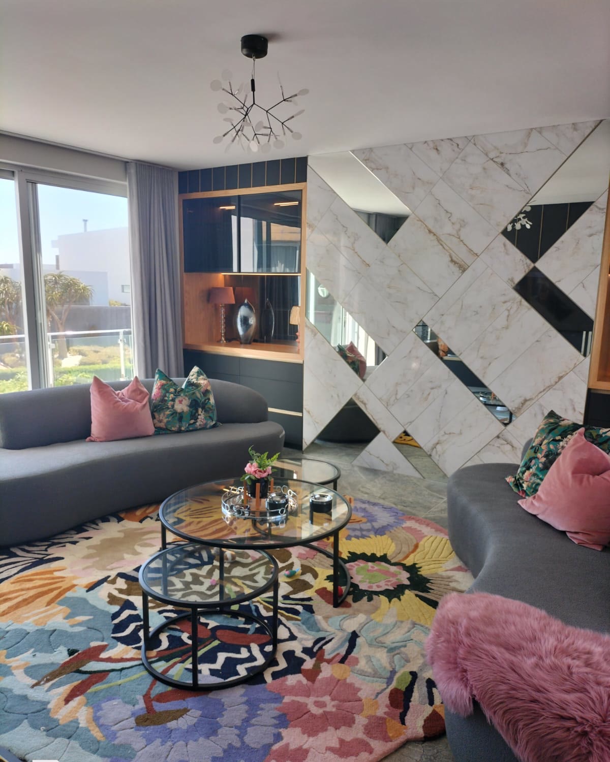 Living room with a book-matched marble-effect porcelain feature wall behind a built-in display unit
